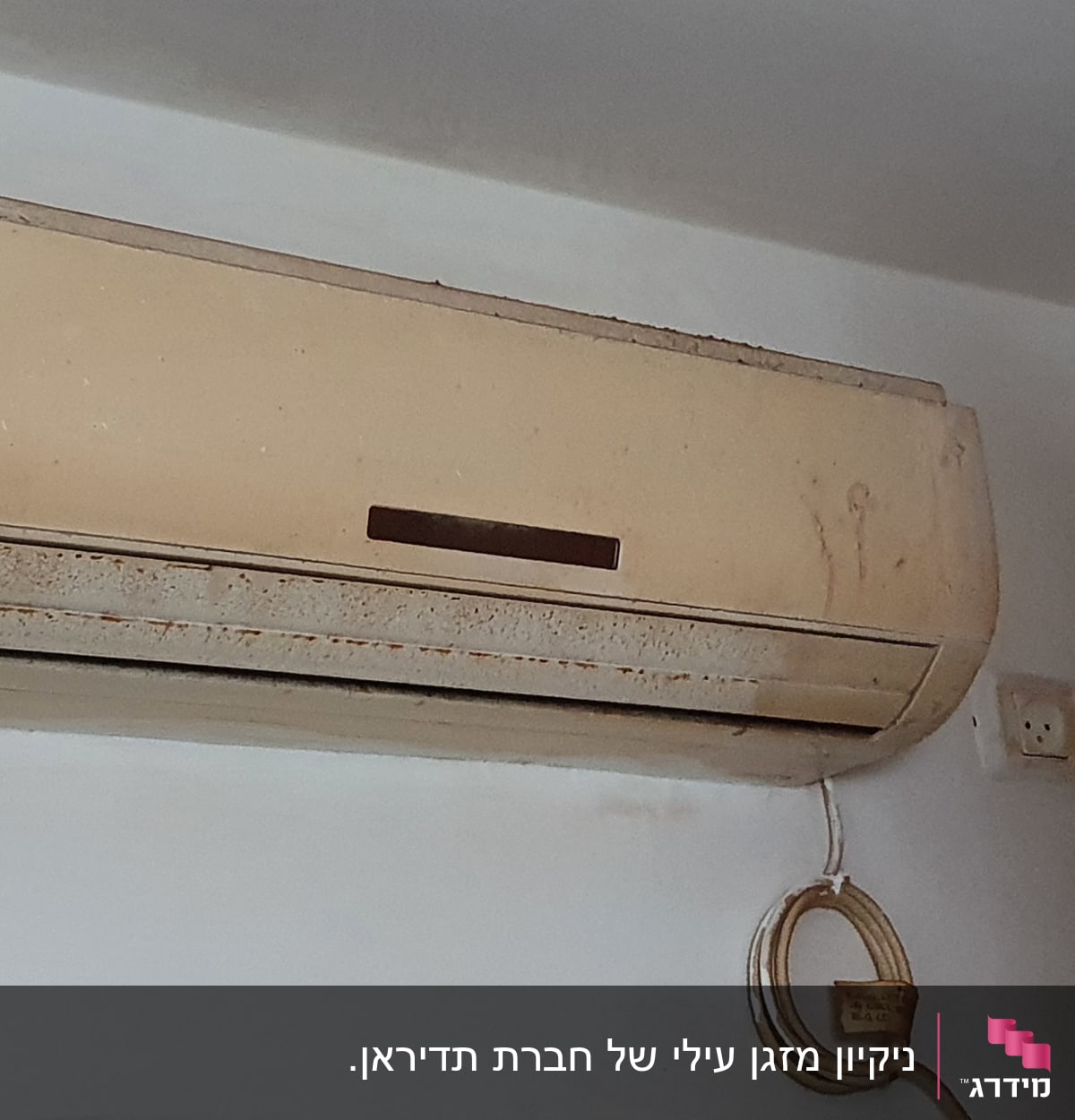 מזגן קיר ישן עם לכלוך וחוט חשמל